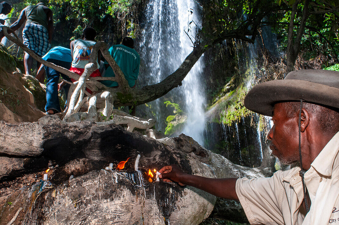 Haiti Voodoo Festival in Saut d'Eau, in Saut d'Eau, Ville Bonheur, Haiti. Tausende von Vodou- und katholischen Anhängern versammelten sich unter dem Wasserfall von Saut d'Eau in Haiti. Die Wallfahrt, die sowohl von Voodou-Anhängern als auch von Katholiken unternommen wird, hat ihren Ursprung in der Sichtung des Bildes der Jungfrau Maria auf einem Palmblatt in der Nähe des Wasserfalls vor einem halben Jahrhundert. Der Katholizismus und die Voodou-Praktiken sind in ihrer haitianischen Form für immer miteinander verwoben. Das Erscheinen eines Regenbogens unter den Wasserfällen soll bedeuten, dass