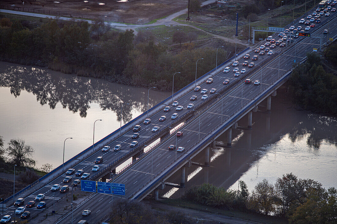 Fahrzeuge fließen über die Autobahn A-49, die den Fluss Guadalquivir überquert und sich in den Abendstunden Sevilla nähert.