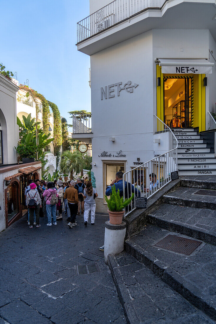 Touristen und Geschäfte auf einer Straße in der Stadt Capri, der größten Gemeinde der Insel Capri, Italien.