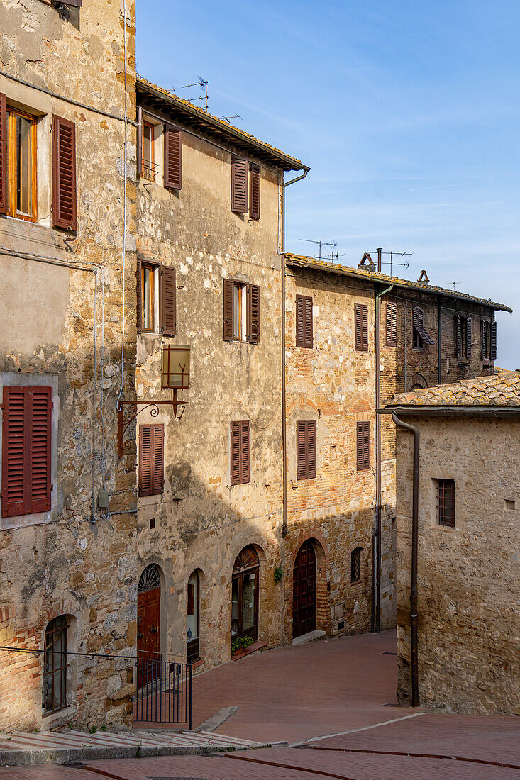 A medieval architecture on a side street in the walled city of San Gimignano, Italy.