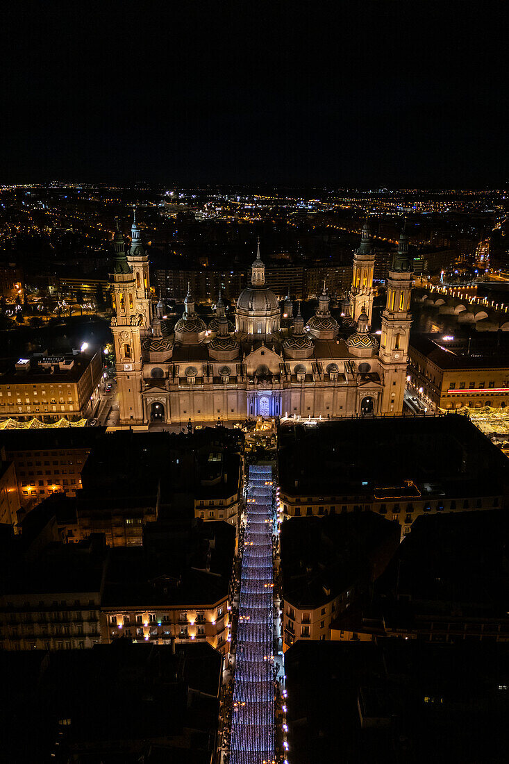 Luftaufnahme der Kathedrale Basilika Unserer Lieben Frau von der Säule und der nächtlich beleuchteten Alfonso-Straße während der Weihnachtszeit, Zaragoza, Spanien