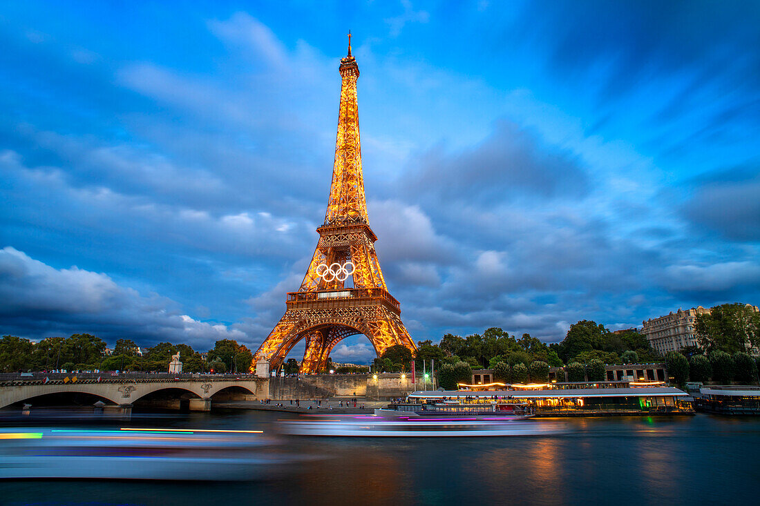 Panorama des Eiffelturms, der Seine und der Pont d'lena in Paris, Frankreich, mit einer vorbeifahrenden Kreuzfahrtfähre.