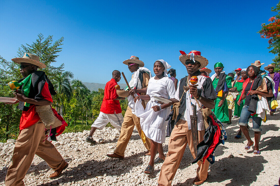 Haiti Voodoo Festival in Saut d'Eau, in Saut d'Eau, Ville Bonheur, Haiti. Tausende von Vodou- und katholischen Anhängern versammelten sich unter dem Wasserfall von Saut d'Eau in Haiti. Die Wallfahrt, die sowohl von Voodou-Anhängern als auch von Katholiken unternommen wird, hat ihren Ursprung in der Sichtung des Bildes der Jungfrau Maria auf einem Palmblatt in der Nähe des Wasserfalls vor einem halben Jahrhundert. Der Katholizismus und die Voodou-Praktiken sind in ihrer haitianischen Form für immer miteinander verwoben. Das Erscheinen eines Regenbogens unter den Wasserfällen soll bedeuten, dass