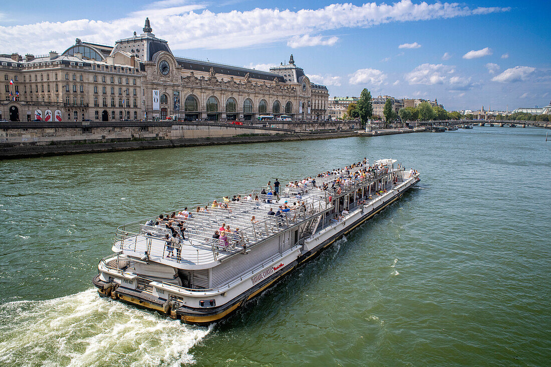 Ein touristisches Kreuzfahrtschiff auf der Seine macht am Pier in der Nähe des Louvre-Museums fest.