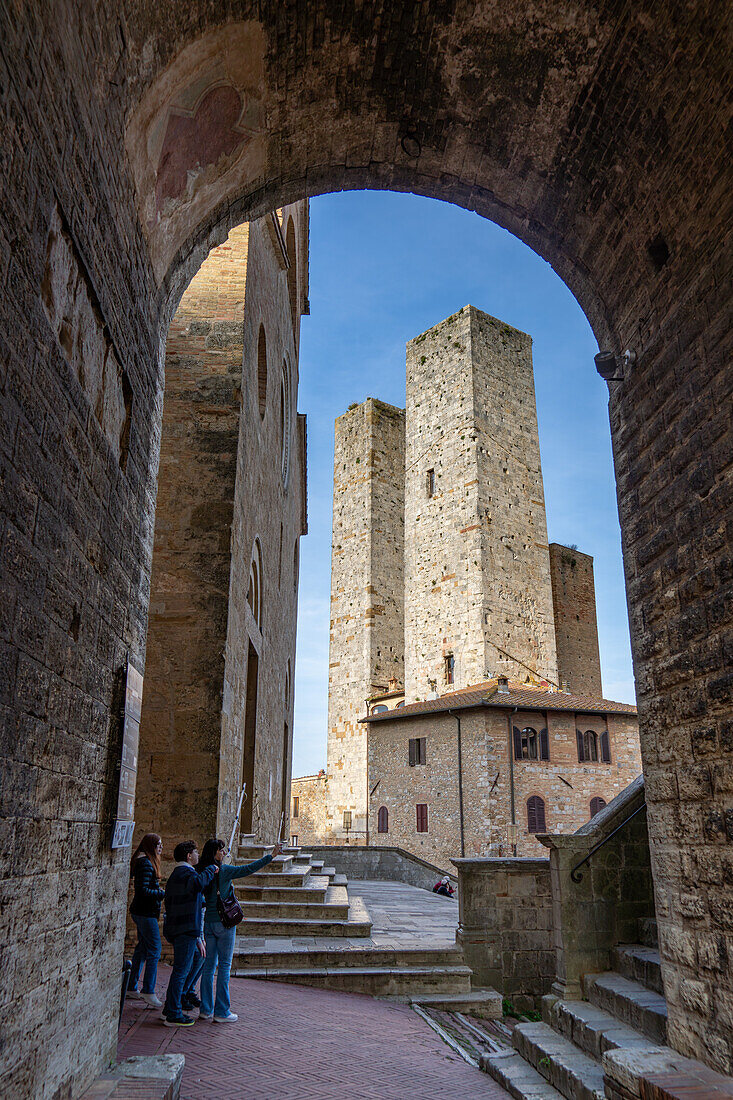 Die Salvucci-Zwillingstürme auf der Piazza della Erbe in der mittelalterlichen Stadt San Gimignano, Italien. Links ist die Fassade der Kirche Collegiata di Santa Maria Assunta zu sehen.