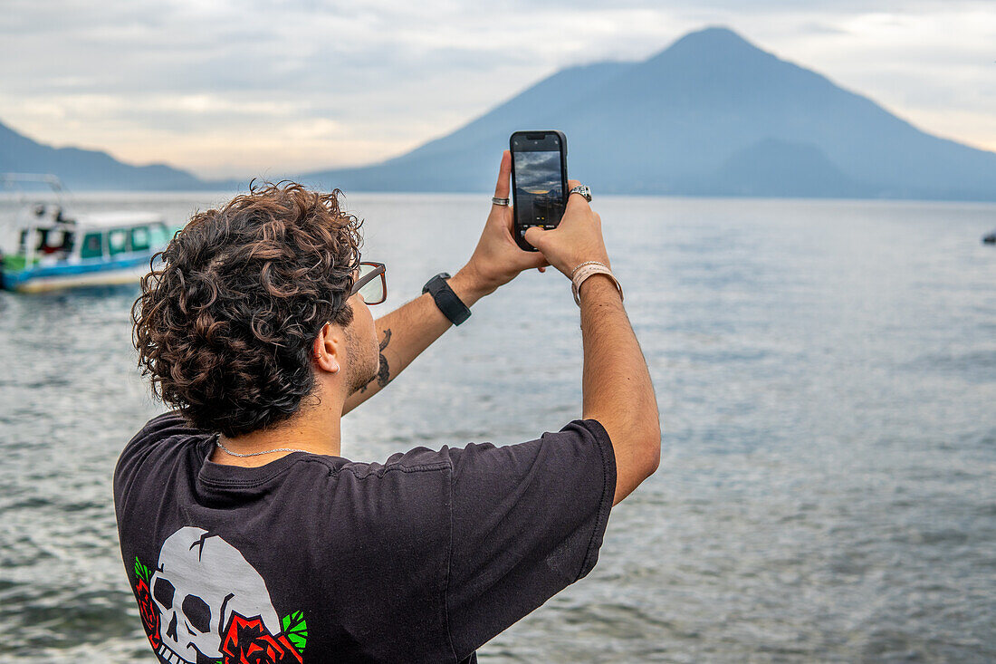 Tourist taking a picture at Lake Atitlan, Guatemala