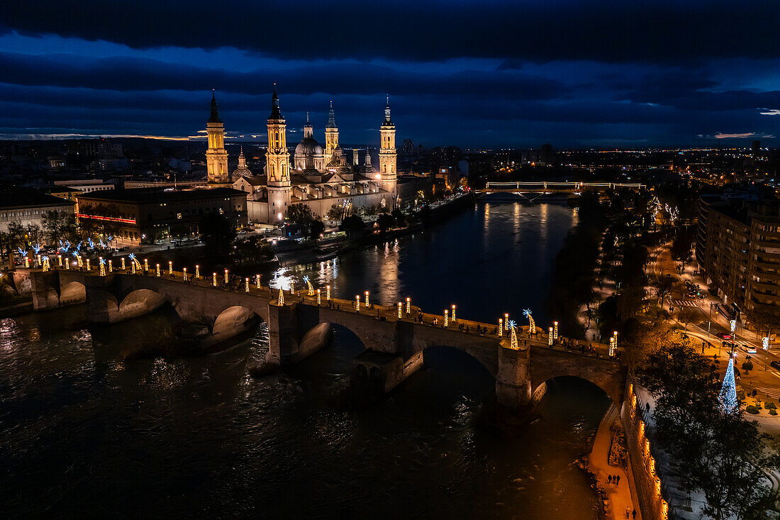 Luftaufnahme der Kathedrale Basilika Unserer Lieben Frau von der Säule und der in der Weihnachtszeit beleuchteten Steinernen Brücke, Zaragoza, Spanien