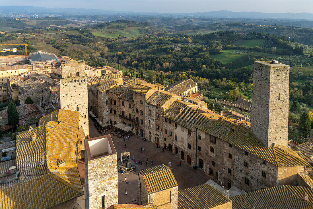 Torre dei Becci, rechts, mit Blick auf die Piazza della Cisterna in der mittelalterlichen Stadt San Gimignano, Italien. Links ist der Torre del Diavolo zu sehen, davor die beiden kürzeren Ardinghelli-Türme.