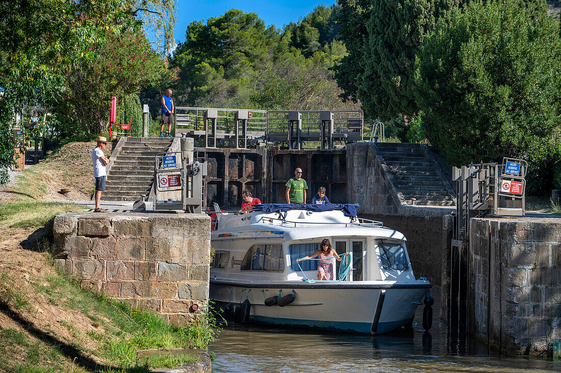 Boat crossing the Écluse de Pechlaurier look. Canal du Midi at village of Argens-Minervois Aude South of France southern waterway waterways holidaymakers queue for a boat trip on the river, France, Europe