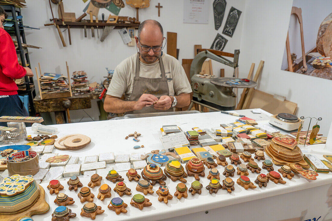 Handwerksmeister Antonino Guarracino bei der Arbeit an Holzintarsien und Laminatschmuck in Sorrento, Italien.