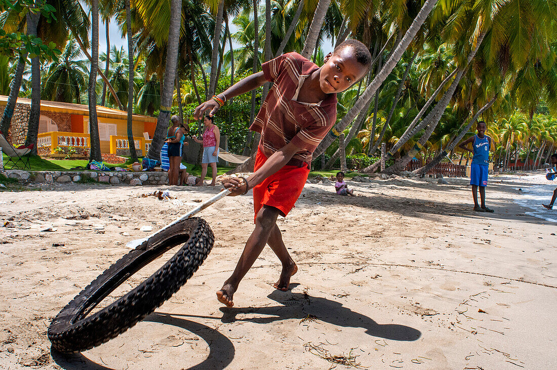 Einheimische Kinder spielen am Strand Plage de Ti Mouillage in Cayes-de-Jacmel, Cayes de Jacmel, Jacmel, Haiti.