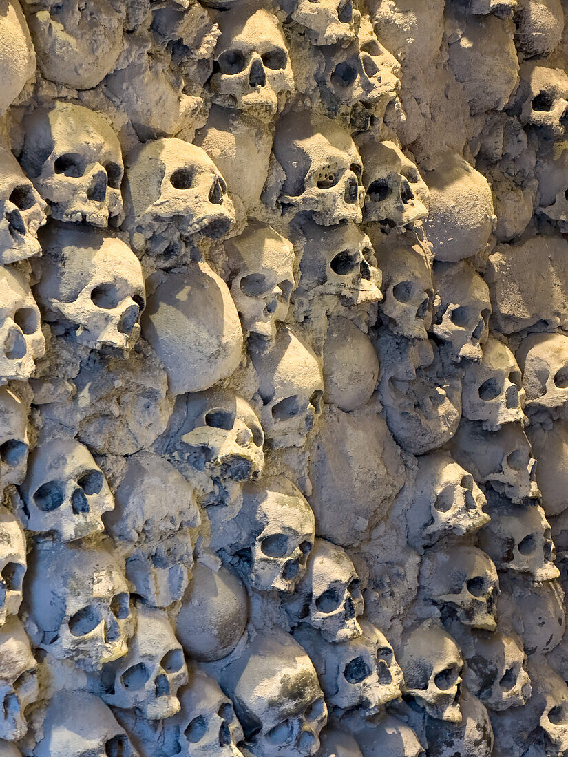 A wall of simulated skulls in the Torture Museum in the medieval walled town of San Gimignano, Italy.