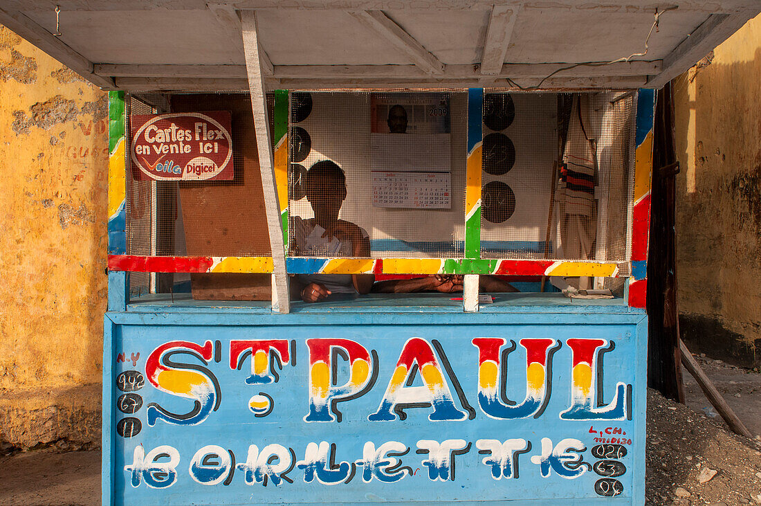 Sale of telephone sims in the local market and houses in the historic colonial old town, Jacmel city center, Haiti, West Indies, Caribbean, Central America