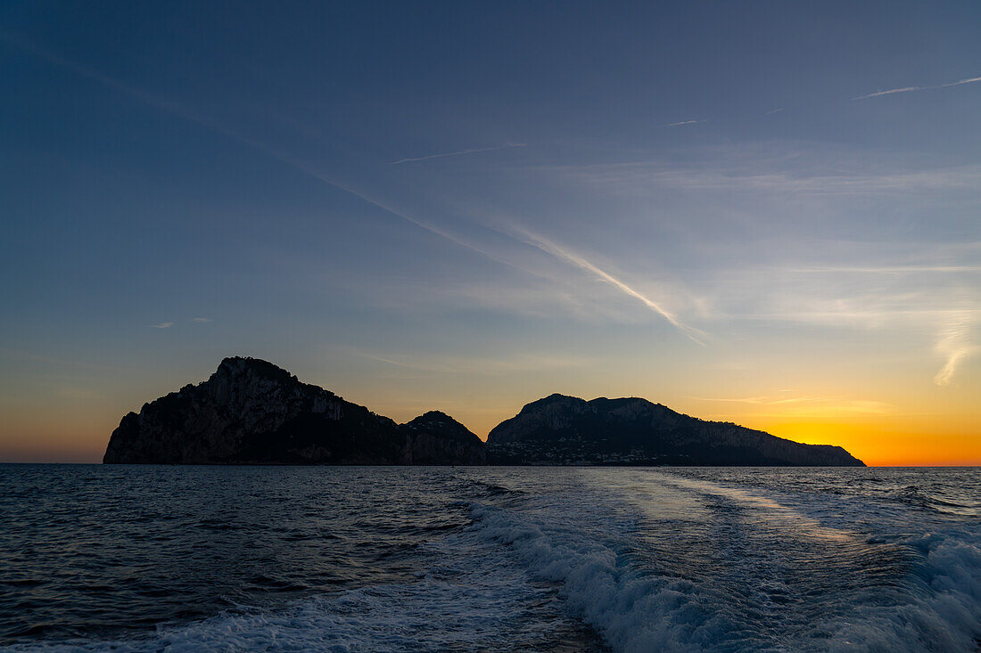 Farbenfroher Himmel über der Insel Capri bei Sonnenuntergang in der Bucht von Neapel, Italien.