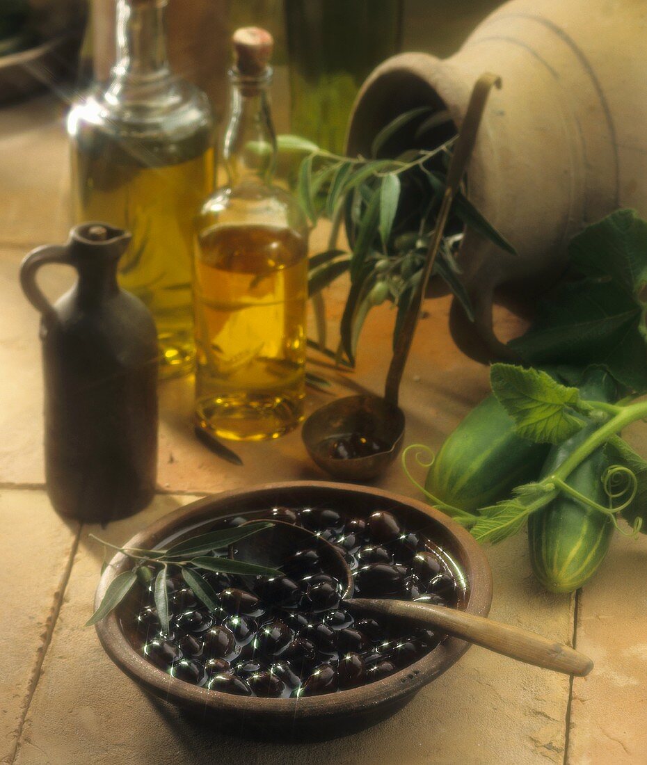 Stillleben mit eingelegten schwarzen Oliven, Olivenöl