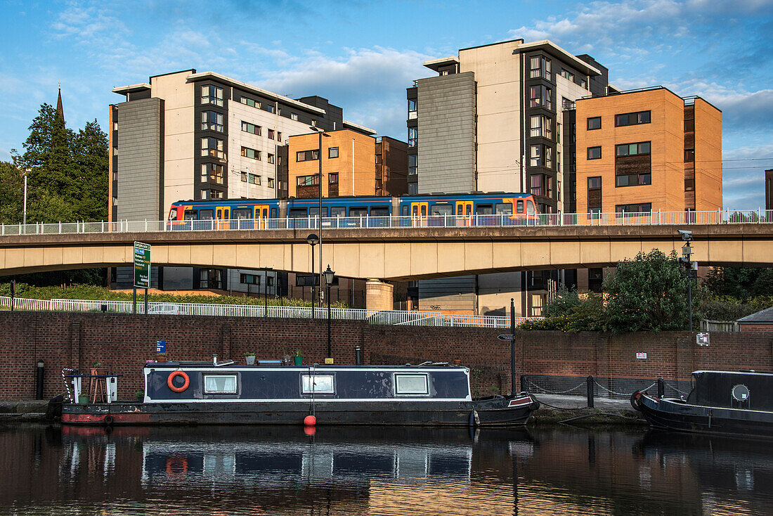 Overhead tram line overlooking canal boats at Victoria Quays, formerly the Canal Basin, Castle Gate Quarter, Sheffield, Yorkshire, England