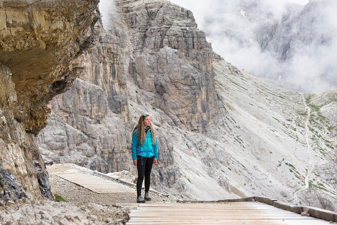 Hiker on path between Locatelli and Pian di Cengia refuges with Punta dei Tre Scarperi behind, Three Peaks Nature Park, Dolomites, South Tyrol, Italy