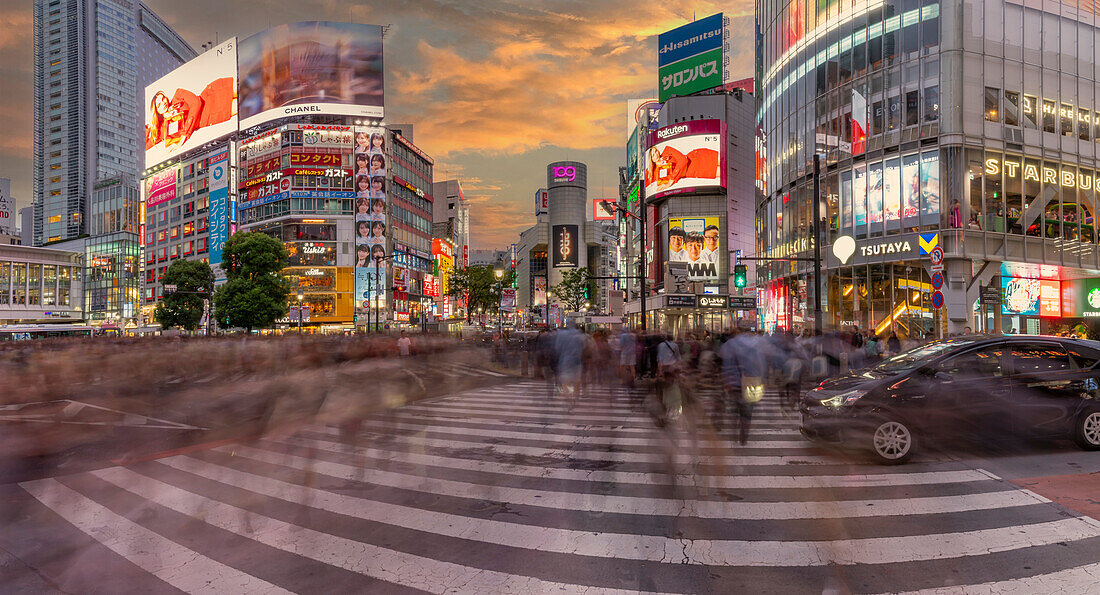 Blick auf Menschen an der belebtesten Straßenkreuzung der Welt, Shibuya Scramble Crossing bei Sonnenuntergang, Minato City, Tokio, Honshu, Japan