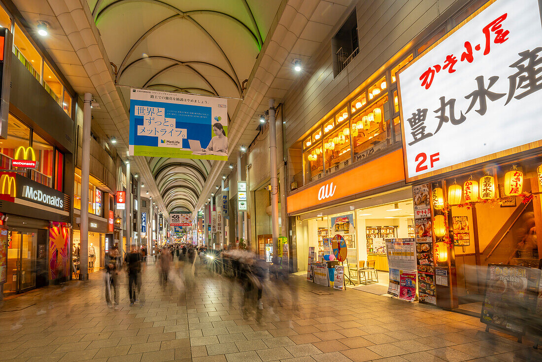 View of colourful shops and restaurants in shopping arcade at night, Hiroshima, Honshu, Japan