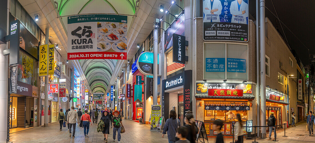 Blick auf bunte Geschäfte und Restaurants in einer Einkaufspassage bei Nacht, Hiroshima, Honshu, Japan