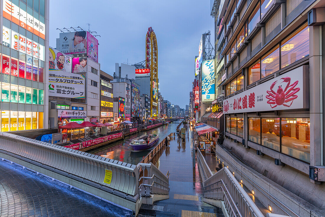 Blick auf bunte Werbeplakate in Dotonbori, pulsierendes Vergnügungsviertel am Fluss in der Abenddämmerung, Osaka, Honshu, Japan