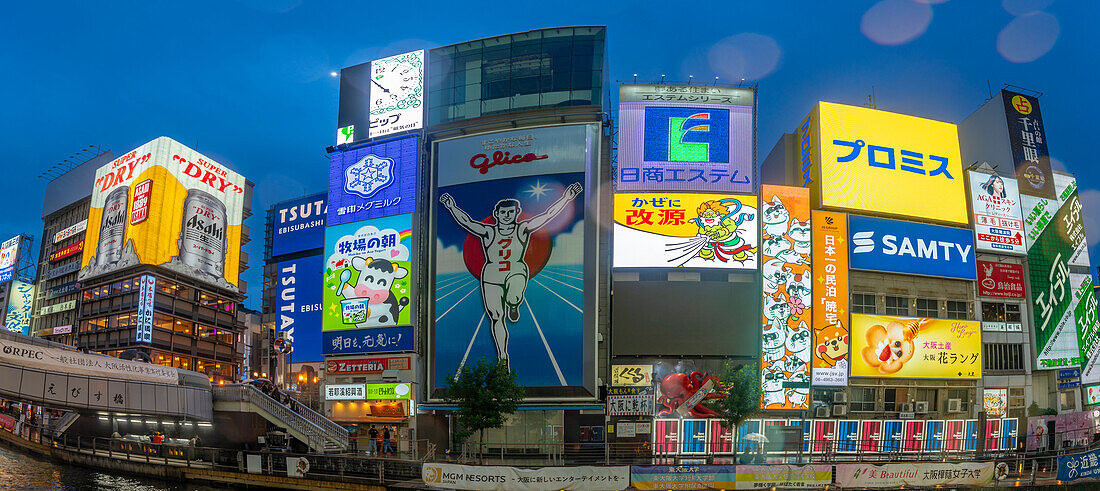 Blick auf das Glico-Schild in Dotonbori, einem pulsierenden Vergnügungsviertel in der Nähe des Flusses, in der Abenddämmerung, Osaka, Honshu, Japan