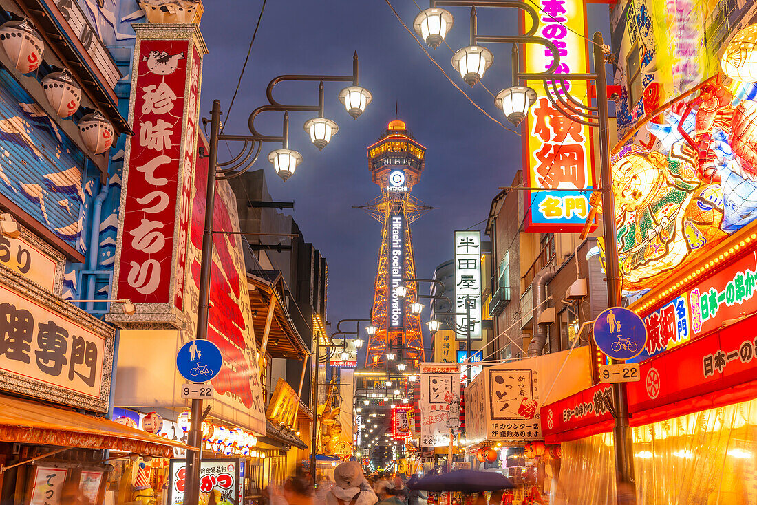 View of Tsutenkaku Tower and restaurants neon lights at dusk in the Shinsekai area, Osaka, Honshu, Japan