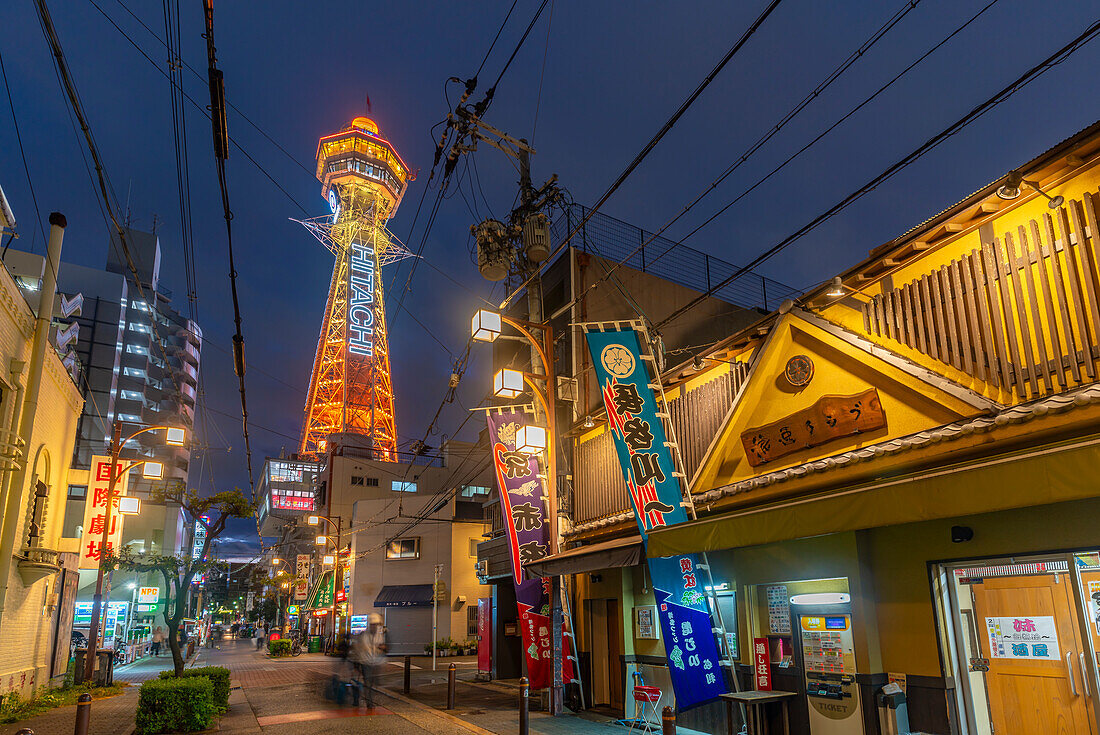 Blick auf den Tsutenkaku-Turm und die Neonlichter der Restaurants in der Abenddämmerung im Shinsekai-Viertel, Osaka, Honshu, Japan