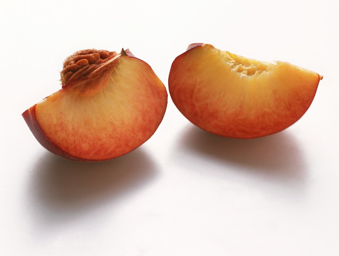 Two Peach Slices, One with Pit