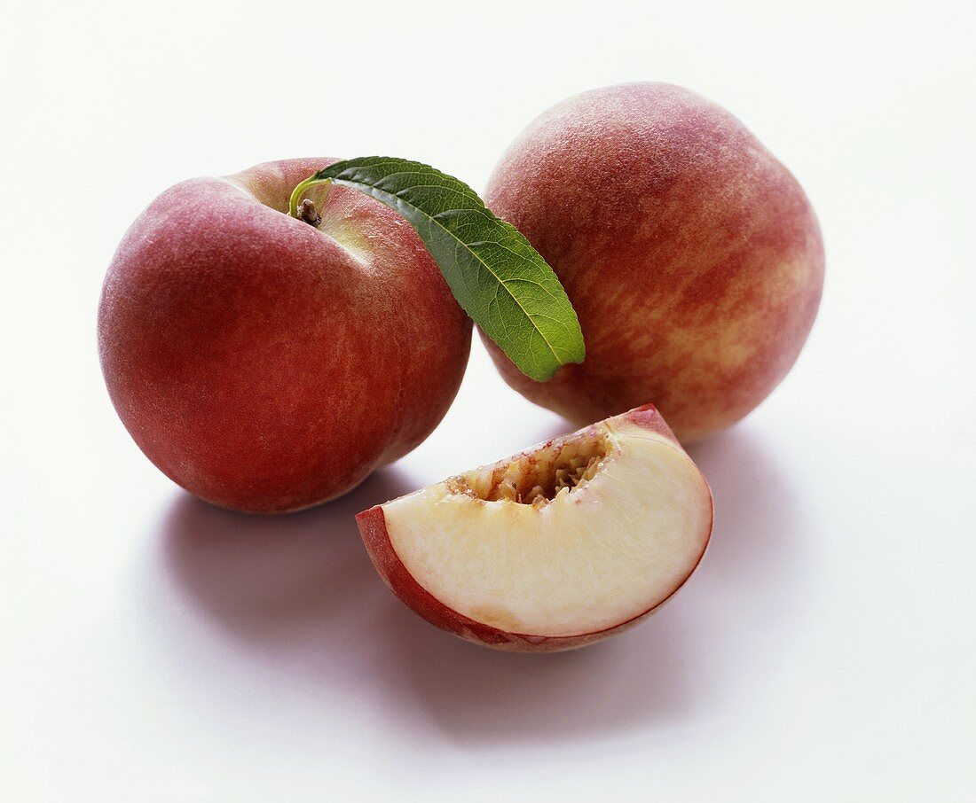 Two peaches and one peach quarter without stone