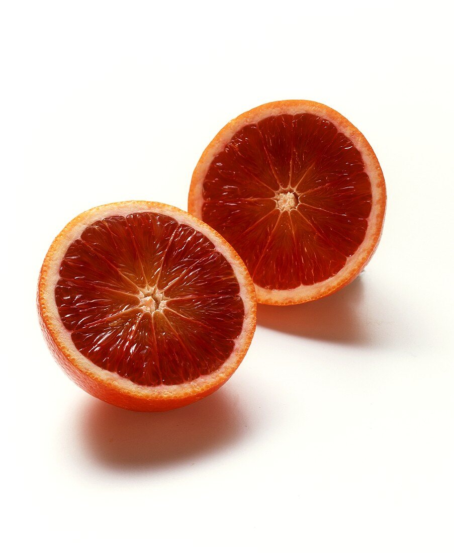 Two blood oranges halves on white background