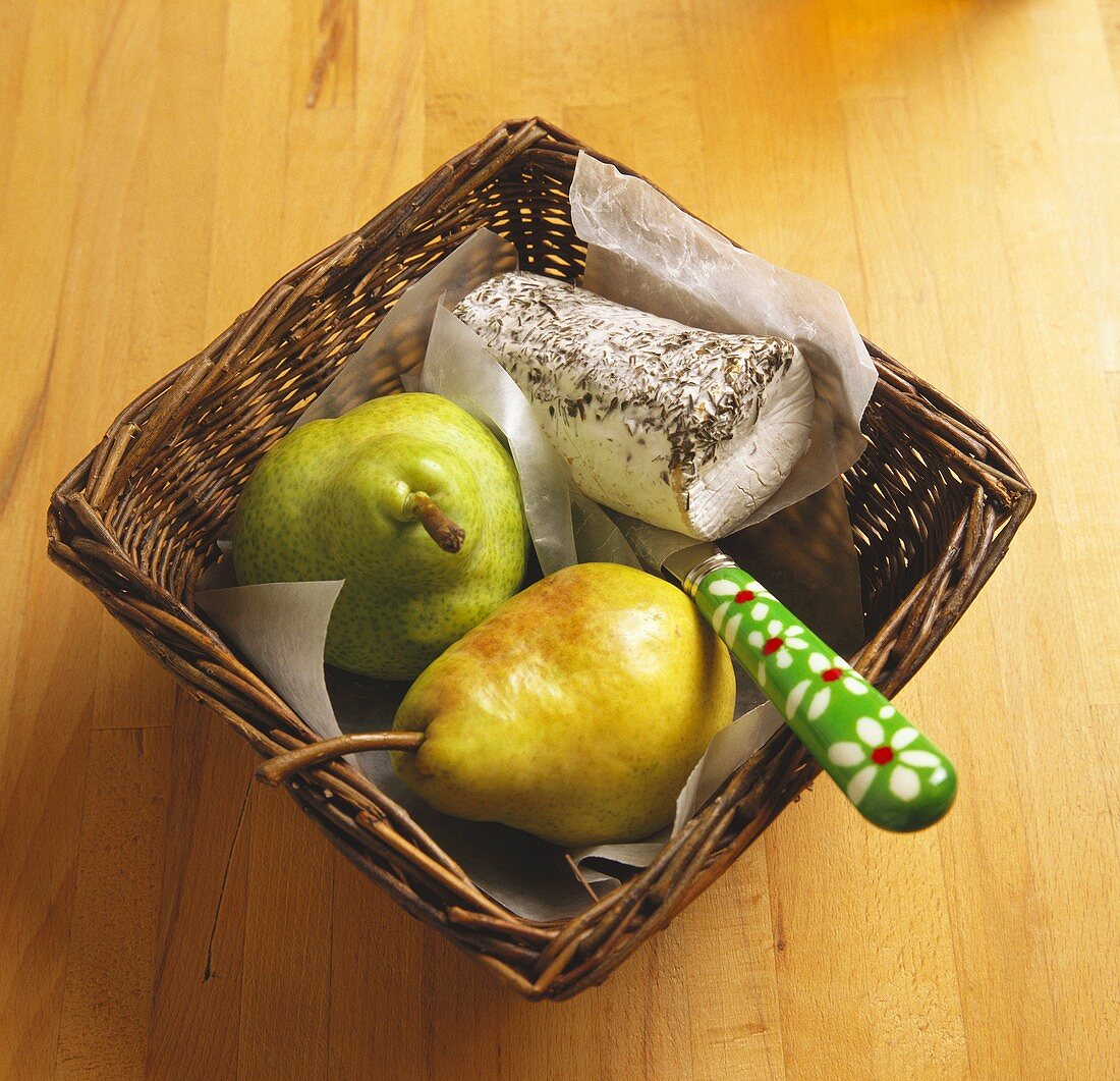 Blue cheese roll with pears and knife in basket