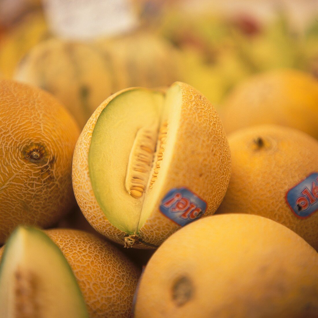 Zuckermelonen, eine davon angeschnitten, auf einem Markt