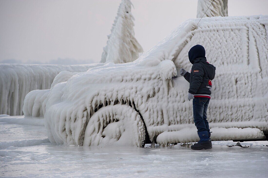 Switzerland, Canton of Vaud, Versoix, the edges of Lake Geneva covered with ice in very cold weather, a car caught by the ice in one night