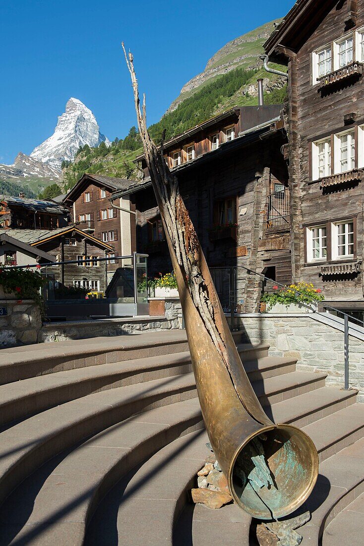 Schweiz, Wallis, Zermatt im Dorf, die Skulptur eines bronzenen Horns der Alpen und der Platz des Rathauses mit dem Matterhorn