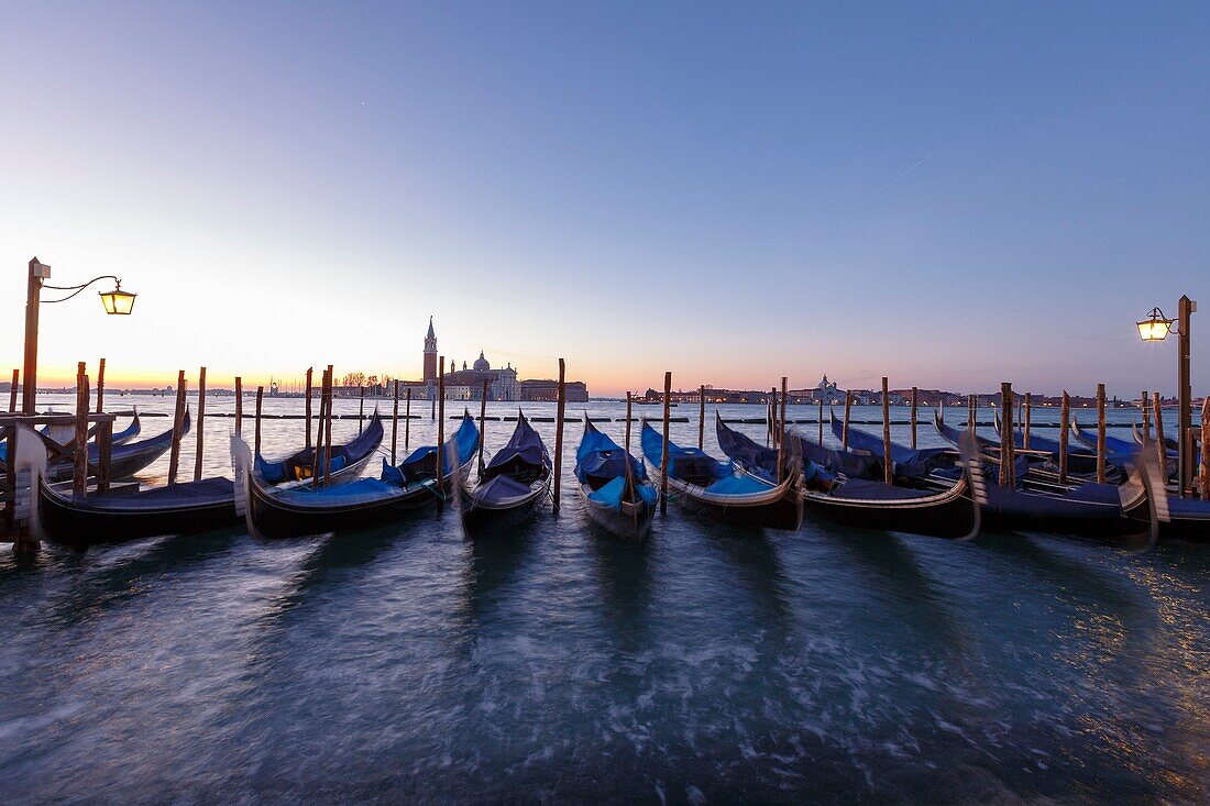 Italien, Venetien, Venedig, von der UNESCO zum Weltkulturerbe erklärt, Stadtteil San Marco, Markusplatz (Piazzetta San Marco), Gondeln am Kai der Riva degli Schiavoni, im Hintergrund die Basilika und die Abteikirche von San Giorgio Maggiore