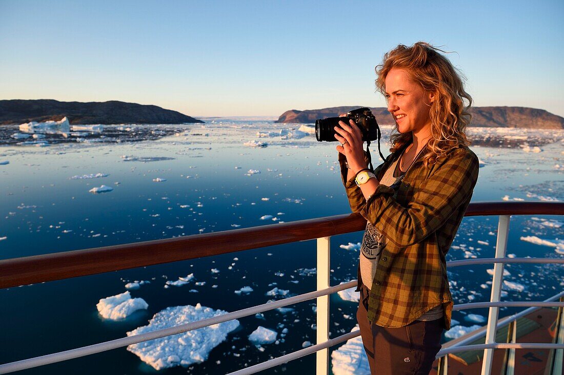 Grönland, Westküste, Diskobucht, Hurtigruten MS Fram Kreuzfahrtschiff bewegt sich zwischen Eisbergen in der Quervainbucht bei Sonnenuntergang und dem Gletscher Kangilerngata sermia im Hintergrund