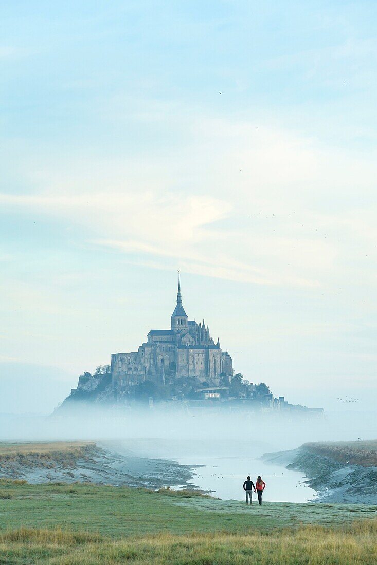 France, Manche, the Mont-Saint-Michel, view of the island and the abbey at sunrise from the mouth of the Couesnon river