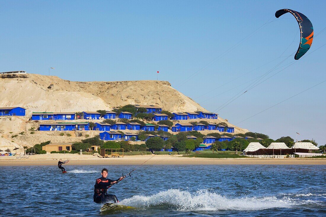 Marokko, Westsahara, Dakhla, Kitesurfer auf der Lagune mit Kitecamp Dakhla Attitude im Hintergrund