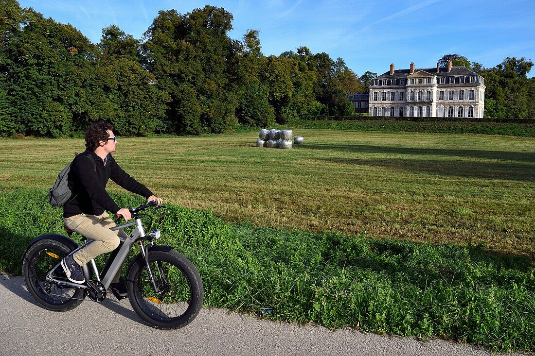 France, Seine-Maritime, Norman Seine River Meanders Regional Nature Park, Sahurs, chateau de Trémauville and cyclist on the veloroute of the Val de Seine