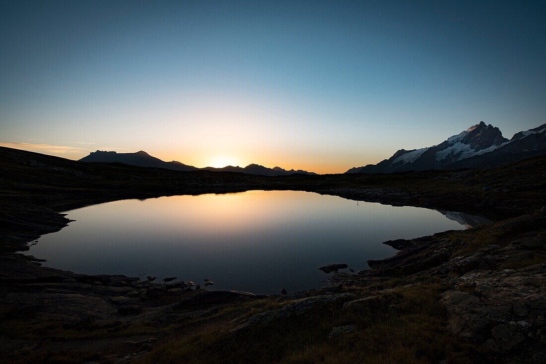 France, Hautes Alpes, la Grave, on the plateau of Emparis the Black Lake facing the massif of Meije at dusk