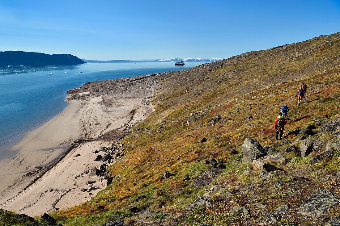 Grönland, Nordwestküste, Murchison-Sund nördlich der Baffin-Bucht, Wanderer im Robertson-Fjord bei Siorapaluk, dem nördlichsten Dorf Grönlands, im Hintergrund die MS Fram, ein Kreuzfahrtschiff von Hurtigruten, vor Anker