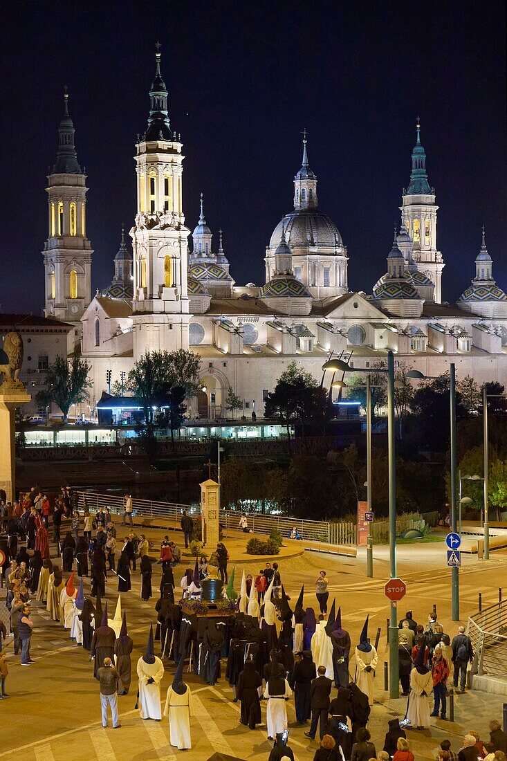 Spain, Aragon Region, Zaragoza Province, Zaragoza, Basilica de Nuestra Senora de Pilar and the Puente de Piedra on the Ebro River, Religious float being carried through the streets during Semana Santa, (Holy Week) celebrations