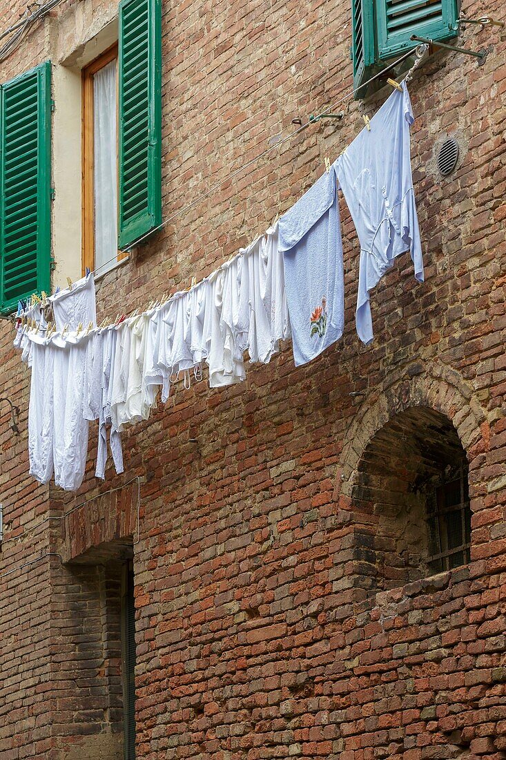 Italien, Toskana, Siena, historisches Zentrum, von der UNESCO zum Weltkulturerbe erklärt, Fassade und hängende Kleidung im historischen Zentrum