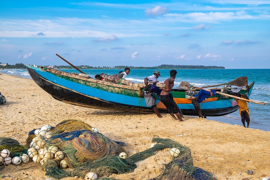 Sri Lanka, Eastern province, Kalkudah, fishermen pulling up their net on Kalkudah beach