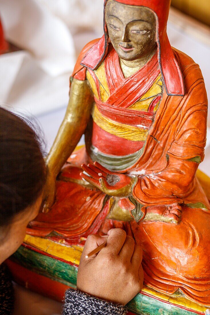India, state of Jammu and Kashmir, Himalaya, Ladakh, Indus valley, Matho monastery (gompa), the restoration workshop where two women from the village of Matho sitting cross-legged, work to restore a very beautiful statue fragile, uncooked clay and plant fiber of about 200 to 300 years. This statue represents a Sakya master