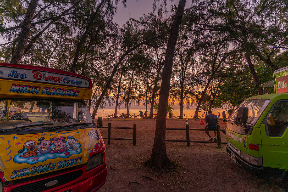 View of people on Mon Choisy Public Beach at sunset, Mauritius, Indian Ocean, Africa