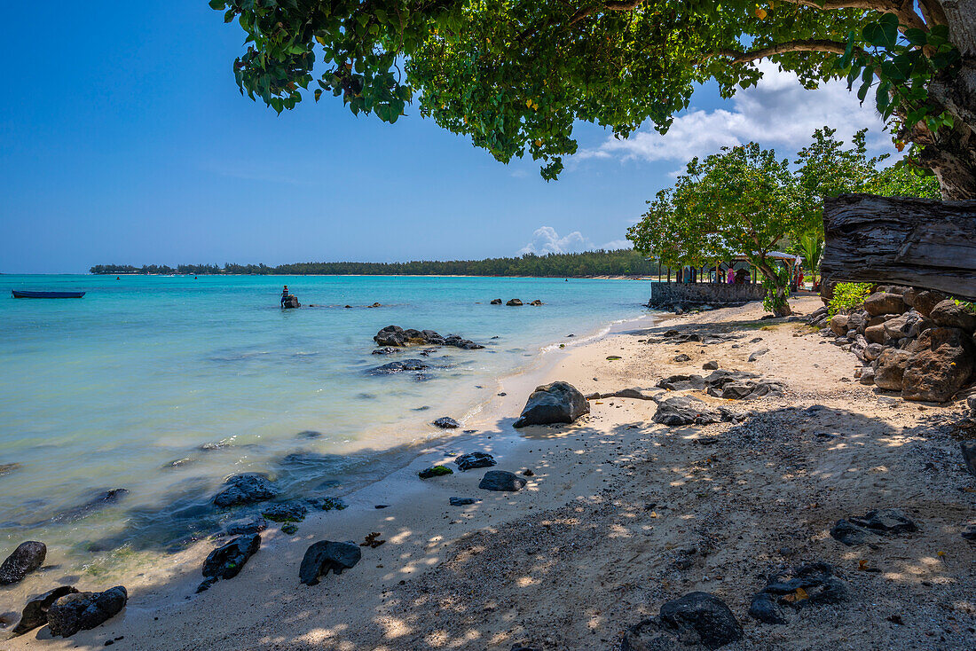 View of man fishing from Mont Choisy Beach and turquoise Indian Ocean on sunny day, Mauritius, Indian Ocean, Africa