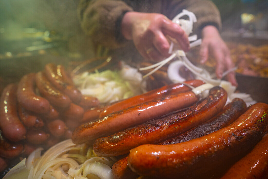 Frankfurter Würstchen an einem Weihnachtsmarktstand auf dem Old Market Square in der Abenddämmerung, Nottingham, Nottinghamshire, England, Vereinigtes Königreich, Europa