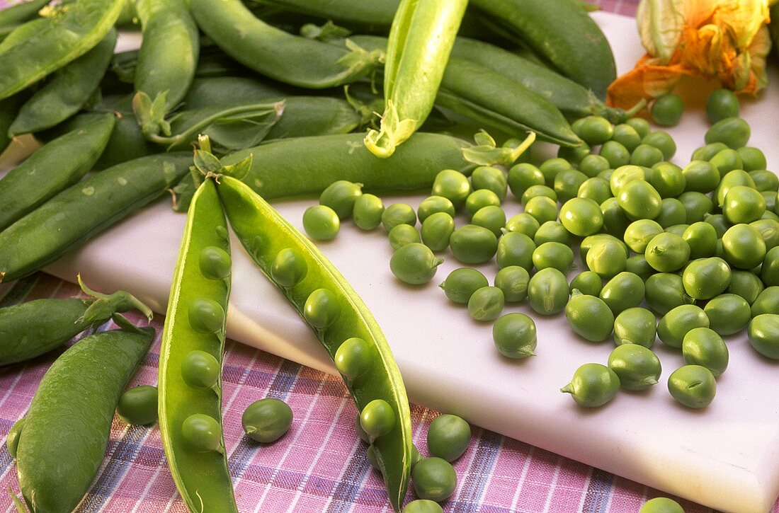 Geöffnete Erbsenschote vor vielen Erbsen & Erbsenschoten